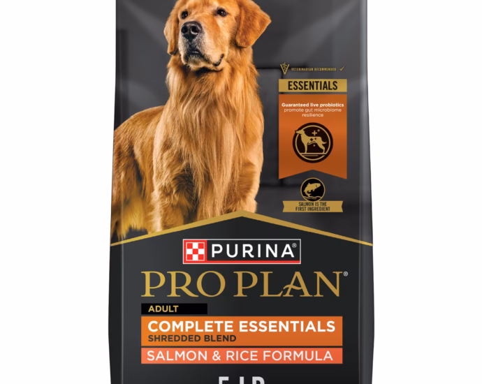 Purina Pro Plan dog food kibble poured into a metal bowl next to the bag