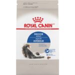 Royal Canin Indoor cat food kibble in a ceramic bowl beside the bag