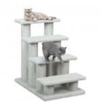 An older gray cat using pet steps to reach a comfortable resting place in a dimly lit room